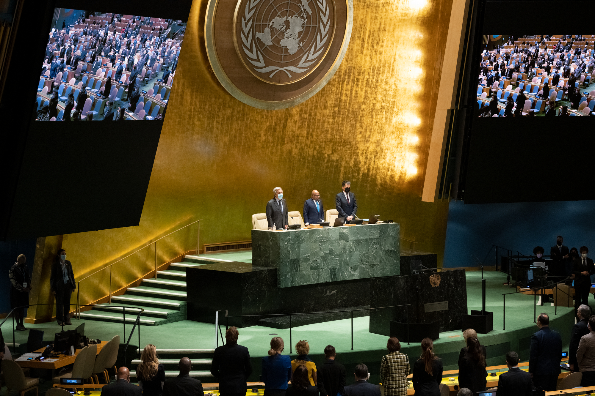 The General Assembly stands for a moment of silence during the first plenary meeting of the eleventh General Assembly Emergency Special Session on Ukraine. At dais are, from left to right: Secretary-General António Guterres; Abdulla Shahid, President of the seventy-sixth session of the United Nations General Assembly, and Movses Abelian, Under-Secretary-General for General Assembly and Conference Management (DGACM).
